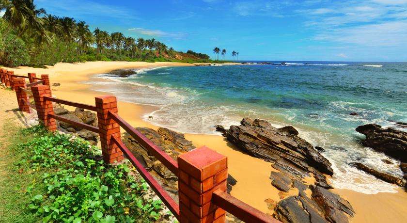 Het strand voor je hotel in een mooie tropische baai<br>
